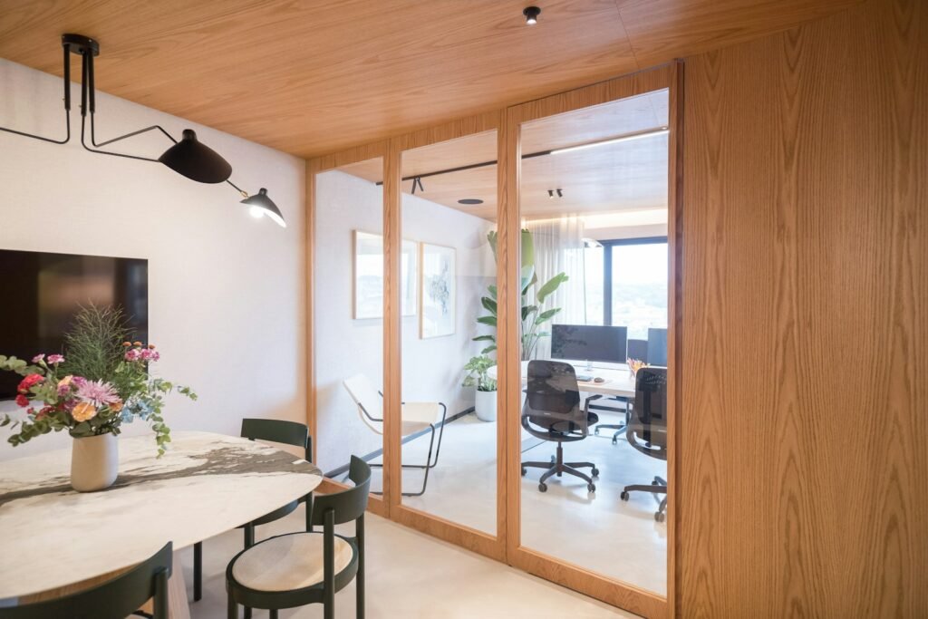 Modern office space with dining area and glass partition.